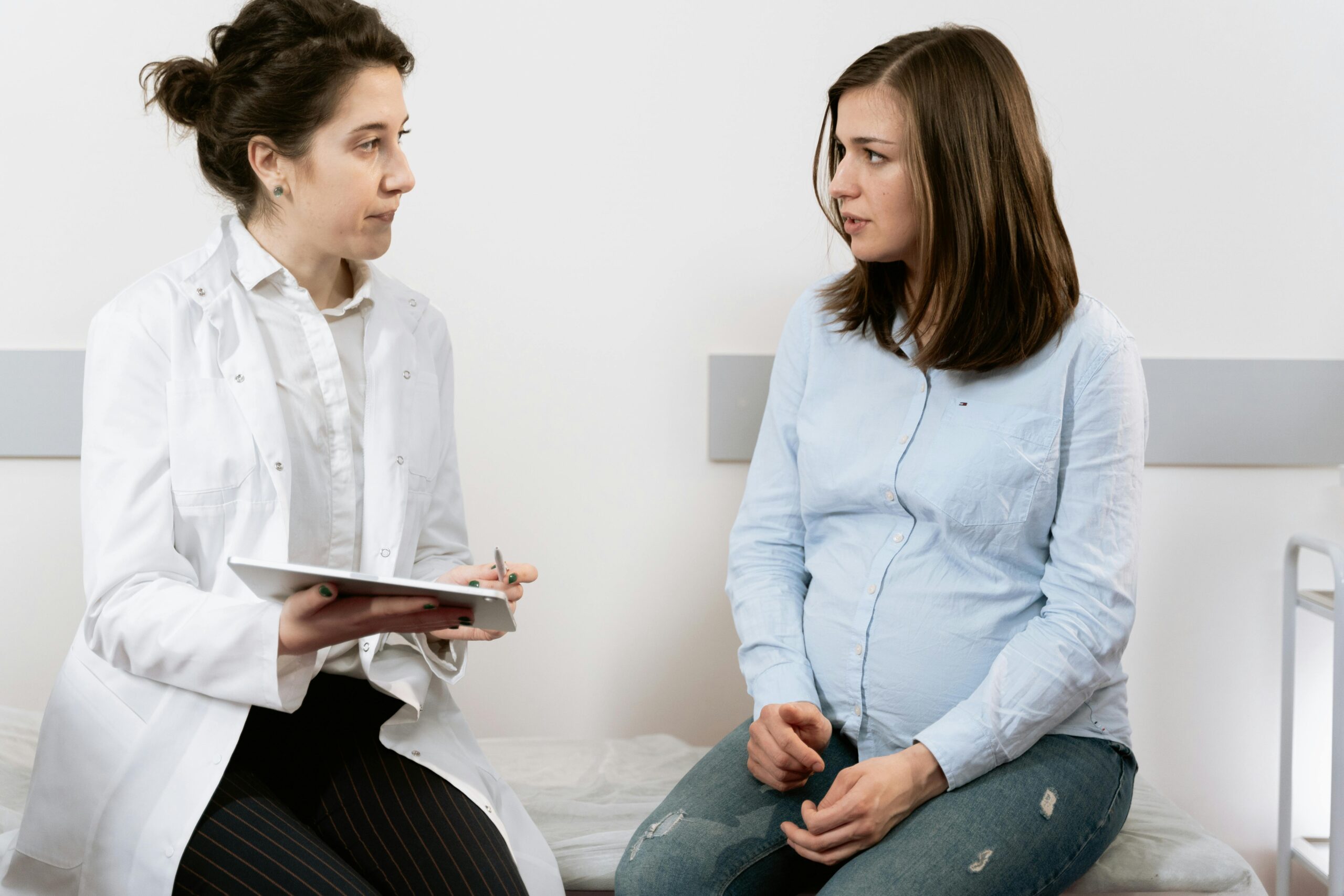 Pregnant woman speaking with doctor during prenatal appointment